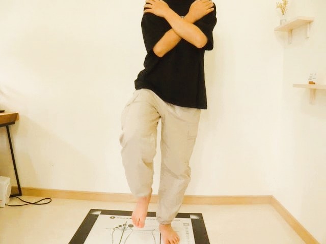 足を前へ上げた片足立ちで身体の傾きとつま先の向きを確認している様子