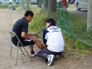 アイシング完全ガイド|どれくらい・何で・いつまで? スポーツ中に足首を痛めたときに、患部を確認している様子