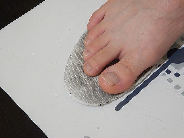 中敷きの上に足を置き、つま先の余裕、踵の位置、足幅が靴の形に収まるかを確認している様子