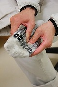 5cm幅の非伸縮テープを第4中足骨付近から貼り始め、足裏の形に沿って小指側へ進める位置を示した写真